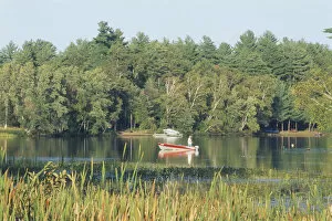 Tourist Attractions Collection: Canada, Ontario, Combemere, man fishing from small boat with an outboard motor on a lake