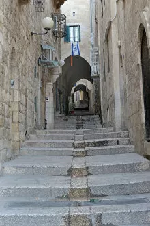 Step Gallery: Deserted alleyway with Israeli flag hanging from a window above an archway, Muslim Quarter