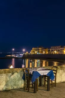 Laid table in restaurant at night, city beach Seno della purita, historic centre, Gallipoli, Province of Lecce, Apulia, Italy