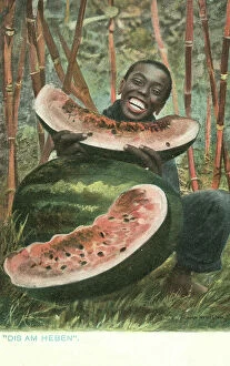 Enjoying Collection: Black man eating a large watermelon (coloured photo)