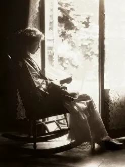 Leisure Time Collection: Woman in a rocking chair in front of the window, circa 1900