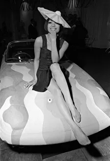 Style Collection: Fashion Clothing Hats April 1964 Fashion model Minerva Smith sitting on bonnet of