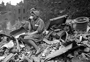 WW2 and WW2 Propaganda Posters: A woman enjoys a cup of tea in the midst of the bomb damage at New Cross after air raids